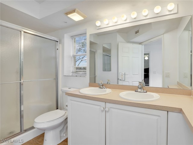 bathroom with toilet, tile patterned flooring, vanity, and walk in shower