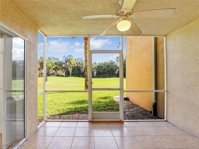 unfurnished sunroom with ceiling fan