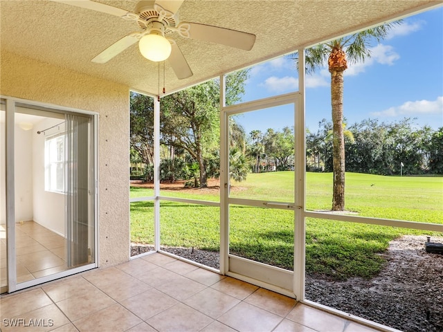 unfurnished sunroom with ceiling fan