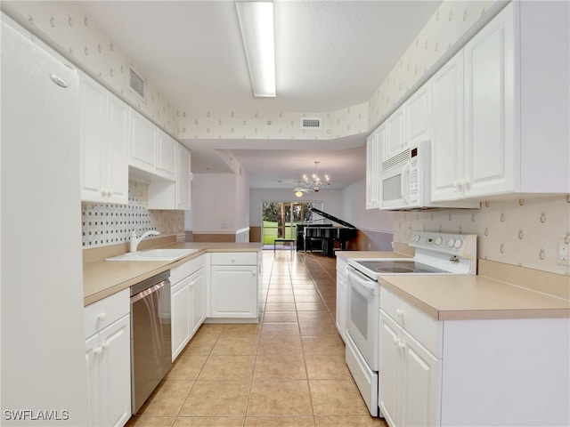 kitchen with kitchen peninsula, white appliances, white cabinetry, and hanging light fixtures