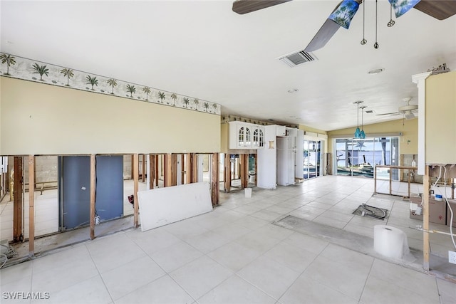 interior space featuring ceiling fan, lofted ceiling, and light tile patterned flooring