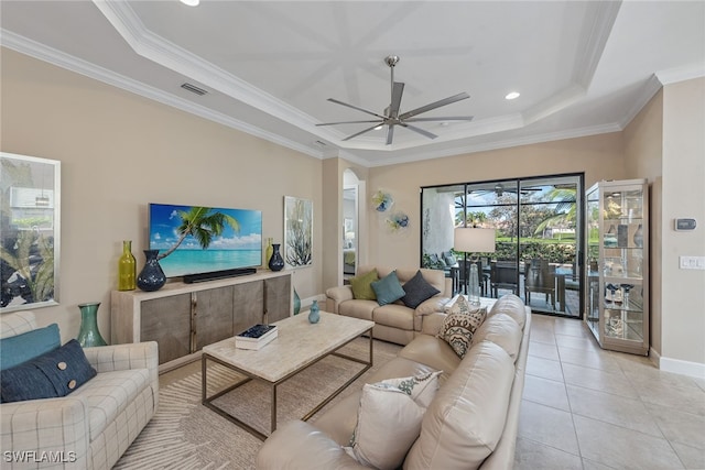 tiled living room with ceiling fan, crown molding, and a tray ceiling