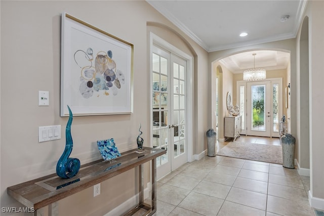 foyer entrance featuring ornamental molding, french doors, a notable chandelier, and light tile patterned flooring