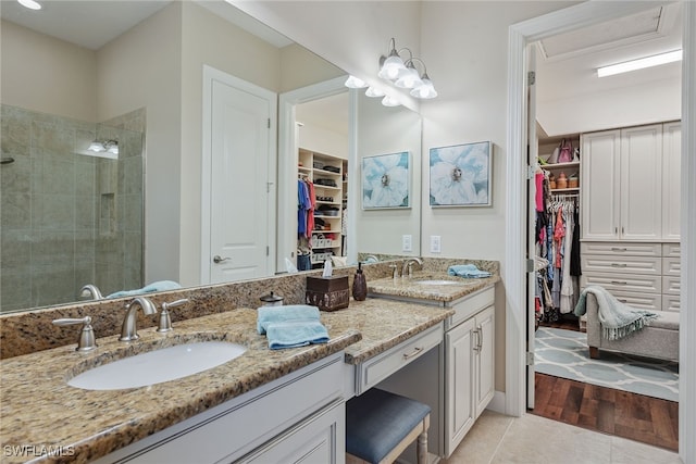 bathroom featuring hardwood / wood-style flooring, vanity, and tiled shower