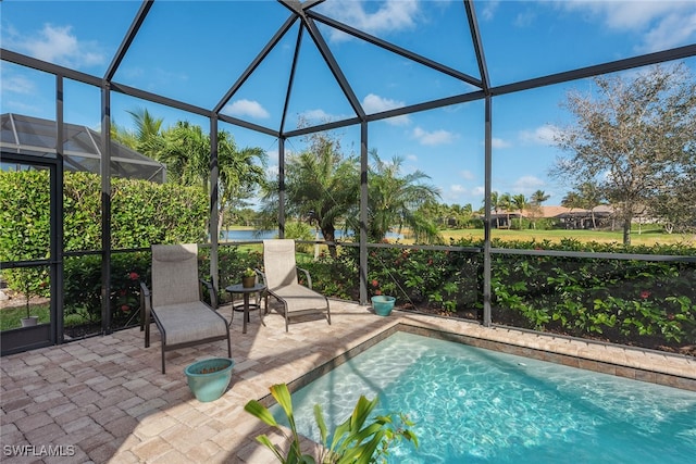 view of swimming pool with glass enclosure and a patio