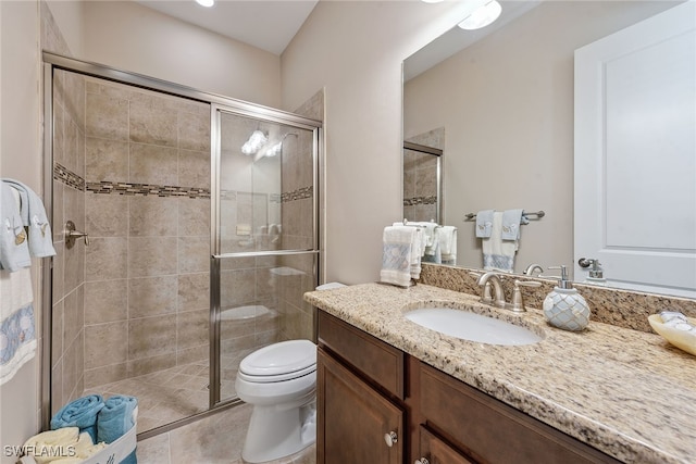 bathroom featuring vanity, tile patterned floors, toilet, and a shower with door