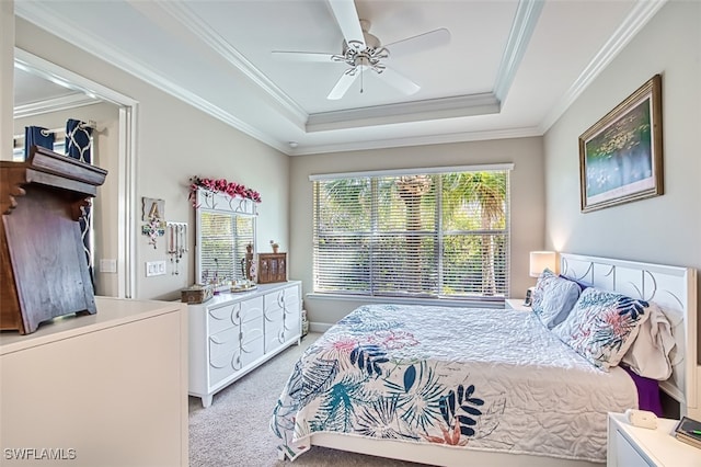 bedroom with light carpet, ceiling fan, crown molding, and a tray ceiling