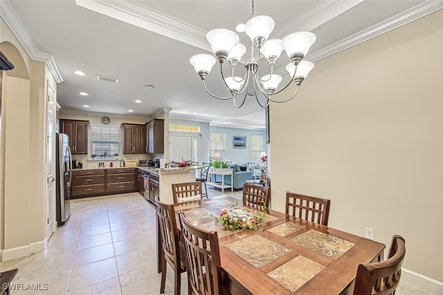 dining space with a wealth of natural light, a notable chandelier, light tile patterned floors, and ornamental molding