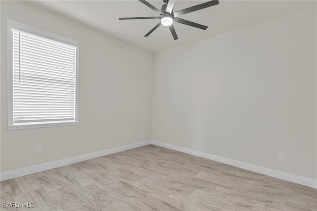 spare room featuring ceiling fan and plenty of natural light