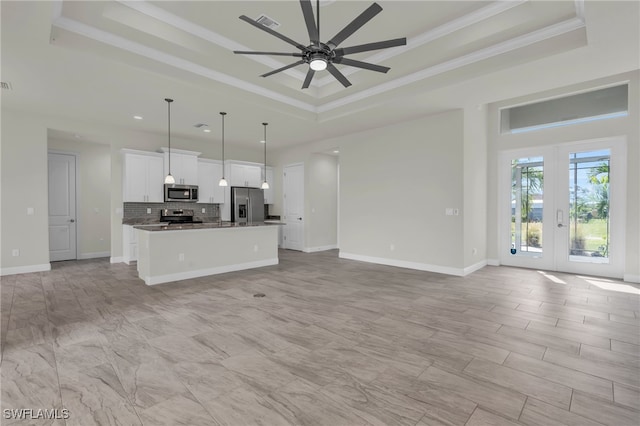 unfurnished living room featuring french doors, crown molding, a tray ceiling, and ceiling fan