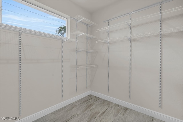 walk in closet with light hardwood / wood-style floors