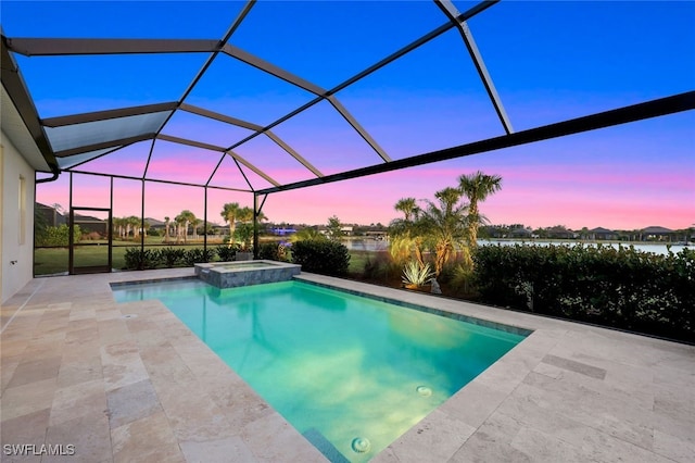 pool at dusk with a lanai, an in ground hot tub, and a patio