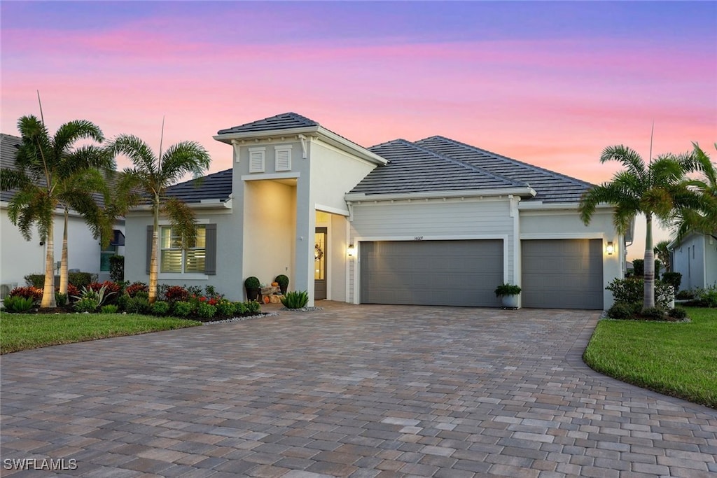 view of front of home with a yard and a garage