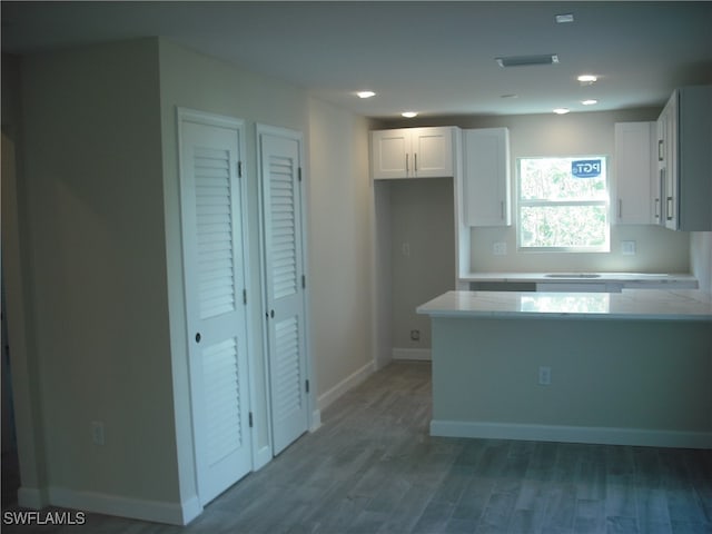 kitchen with wood-type flooring and white cabinets