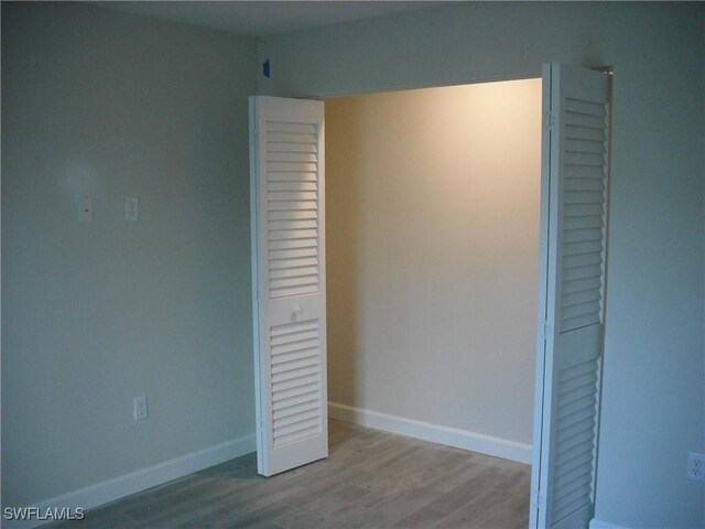 unfurnished bedroom with light hardwood / wood-style floors and a closet