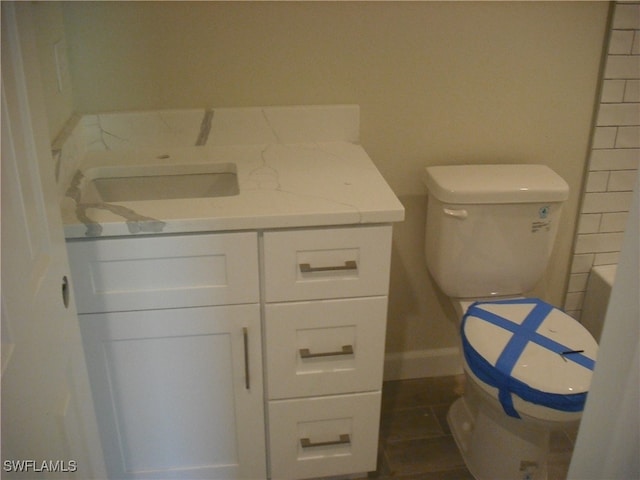 bathroom featuring toilet, vanity, and tile patterned flooring