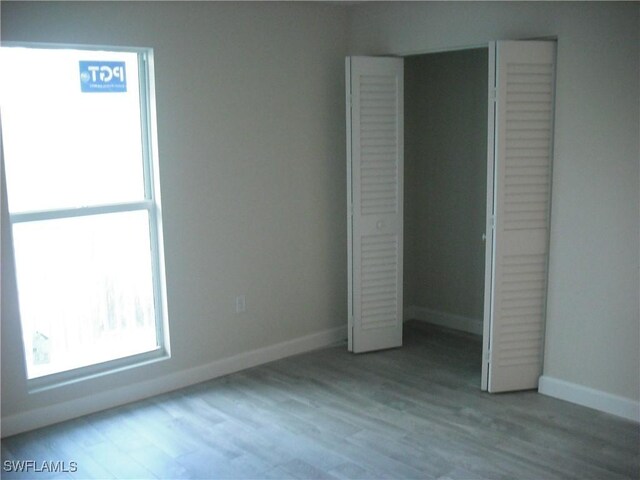 unfurnished bedroom with light hardwood / wood-style flooring and a closet