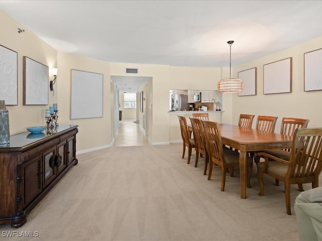 carpeted dining room with a chandelier