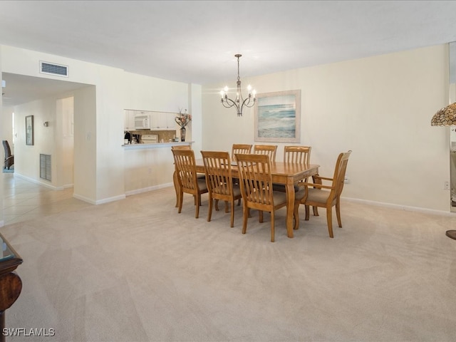 dining room featuring a chandelier and light colored carpet