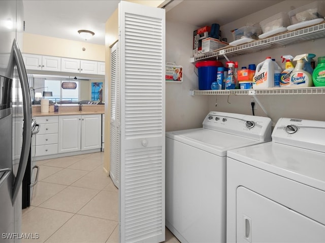 laundry room with washer and clothes dryer and light tile patterned flooring