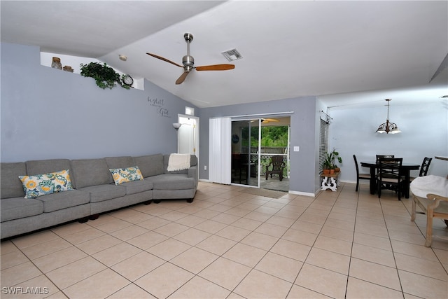 tiled living room featuring vaulted ceiling and ceiling fan with notable chandelier