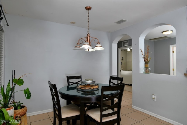 dining space with a chandelier and light tile patterned flooring