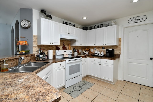 kitchen featuring backsplash, white electric stove, sink, light tile patterned floors, and white cabinets