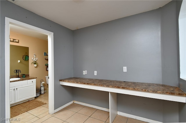 interior space featuring built in desk and light tile patterned floors