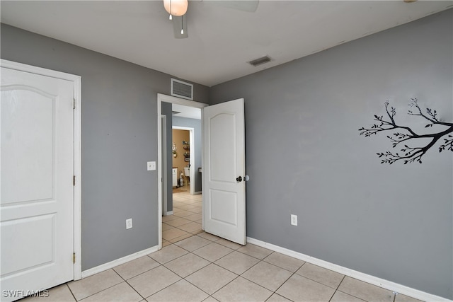 unfurnished bedroom with light tile patterned floors and ceiling fan