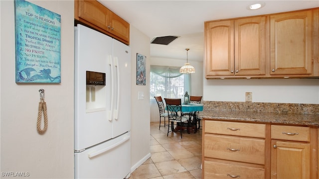 kitchen featuring stone counters, light brown cabinets, decorative light fixtures, and white refrigerator with ice dispenser