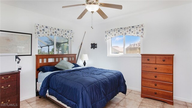 tiled bedroom featuring ceiling fan