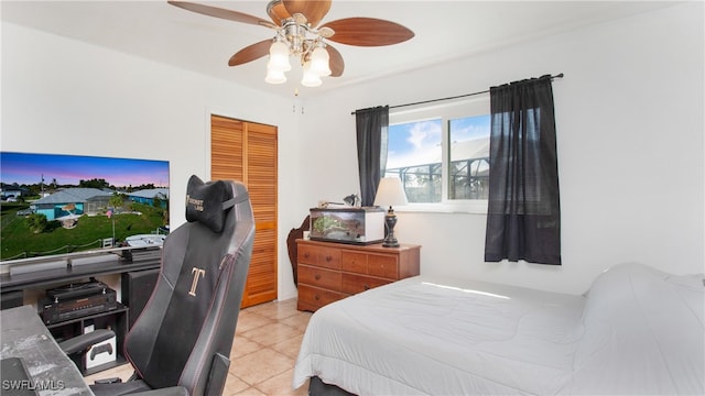 bedroom featuring ceiling fan, a closet, and light tile patterned floors