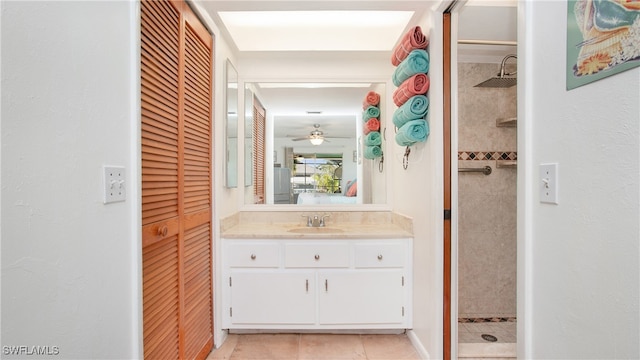 bathroom with ceiling fan, vanity, and tiled shower