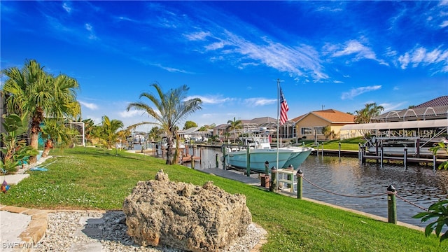 view of dock with a yard and a water view