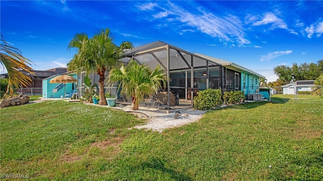 back of property featuring a lanai and a lawn