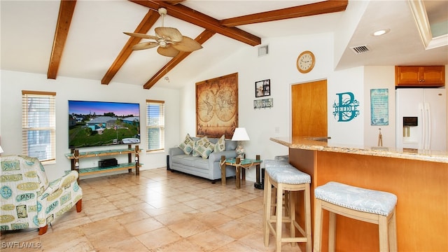 living room with vaulted ceiling with beams, ceiling fan, and a wealth of natural light