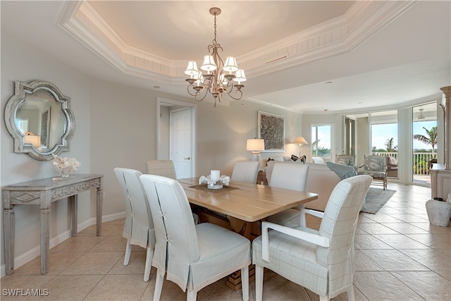 dining area with ornamental molding, a notable chandelier, light tile patterned floors, and a tray ceiling