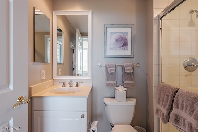 bathroom with an enclosed shower, vanity, and toilet