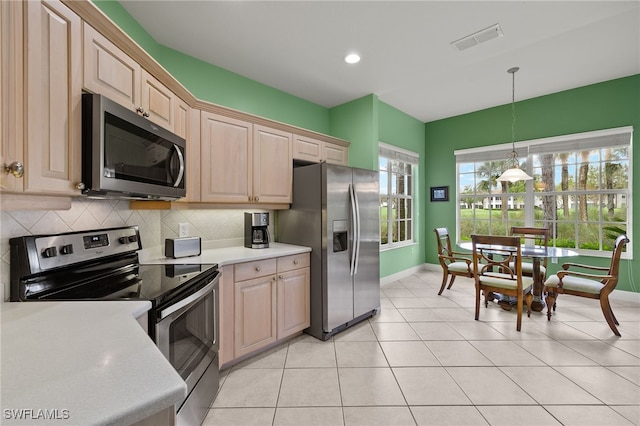 kitchen featuring tasteful backsplash, appliances with stainless steel finishes, pendant lighting, and light brown cabinetry