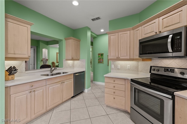 kitchen with sink, light tile patterned floors, stainless steel appliances, and light brown cabinets