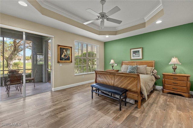 bedroom featuring access to exterior, ceiling fan, light hardwood / wood-style floors, a raised ceiling, and crown molding