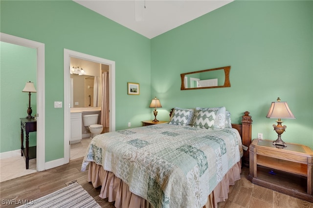 bedroom with wood-type flooring and ensuite bath