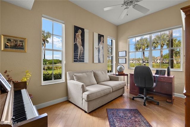 home office with ceiling fan and light hardwood / wood-style floors