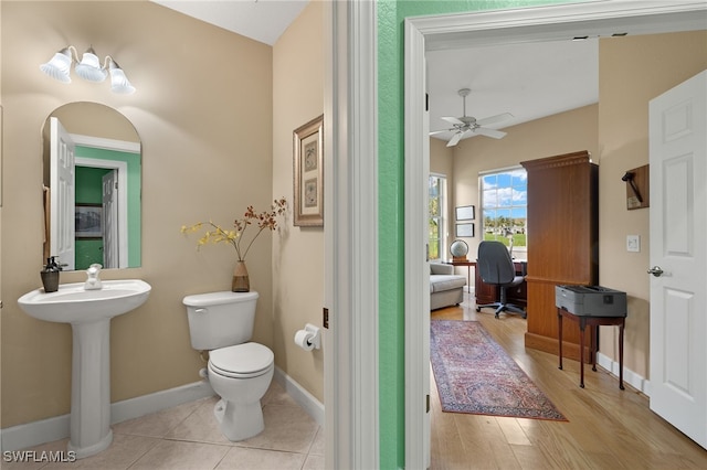 bathroom featuring ceiling fan, wood-type flooring, sink, and toilet