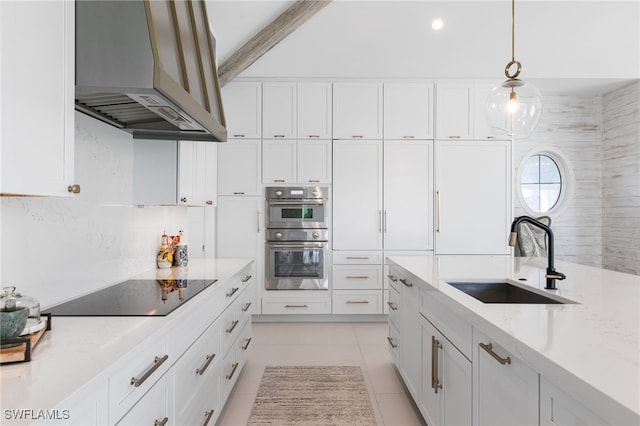 kitchen with white cabinets, wall chimney exhaust hood, sink, and double oven