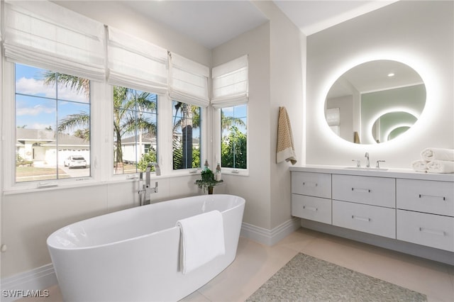 bathroom with tile patterned flooring, vanity, and a tub