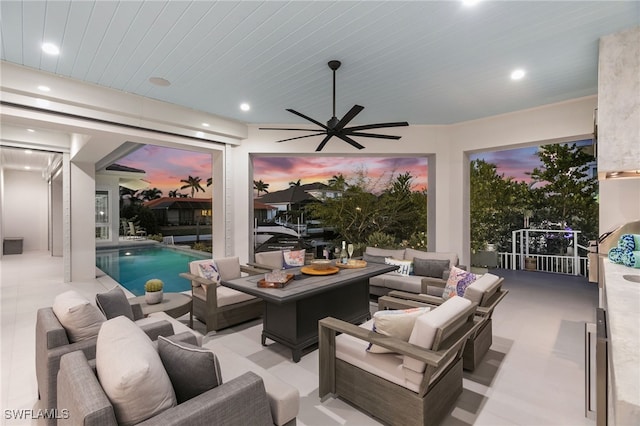 patio terrace at dusk featuring an outdoor living space and ceiling fan