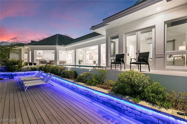 pool at dusk featuring a deck