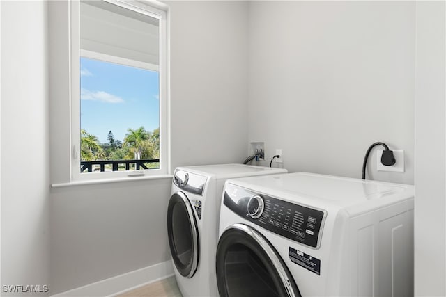 washroom featuring plenty of natural light and washing machine and clothes dryer