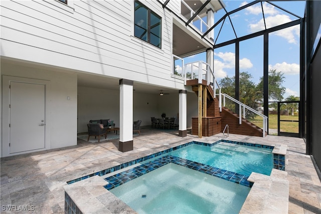 view of pool with an in ground hot tub, a patio, and glass enclosure